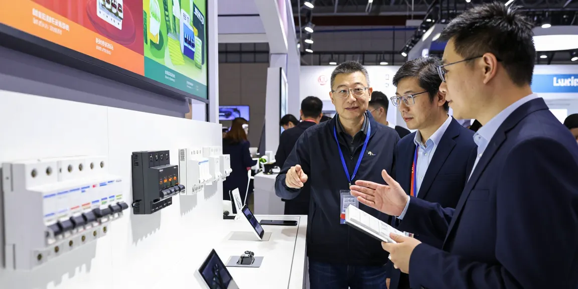 Visitors exploring Langir Electric's dc circuit breaker and anti-vandal switch display at an electronics exhibition.